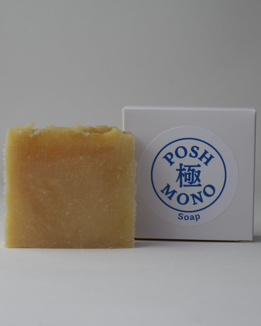 Bar of soap next to its packaging with 'POSH MONO Soap' branding on a gray background