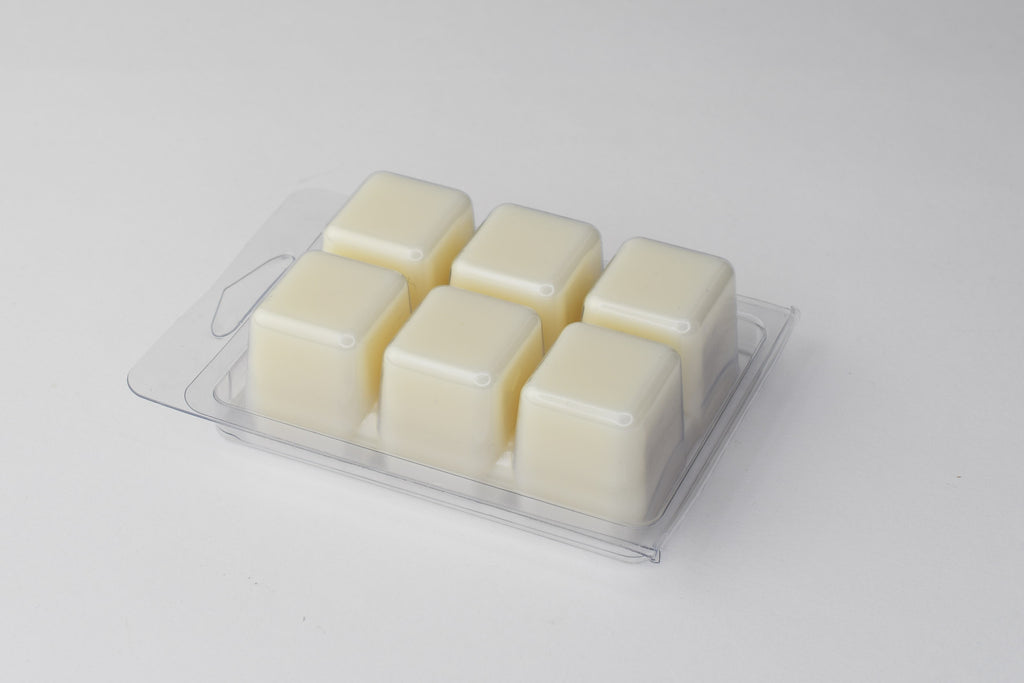 Six square wax melts in a clam shell packag on a light gray background